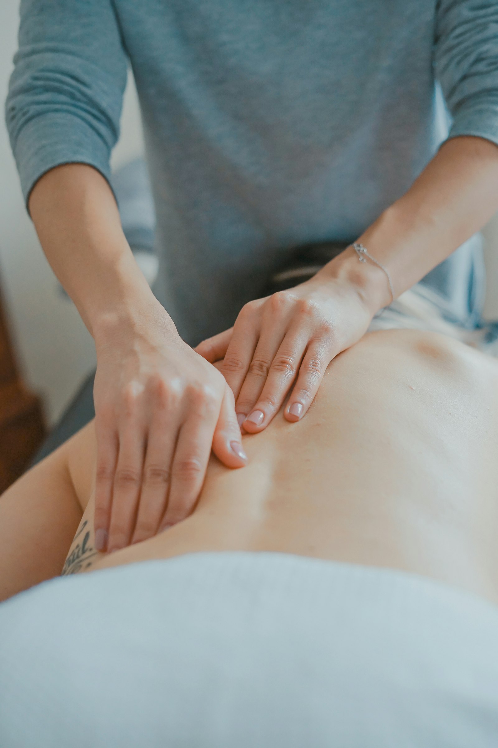 Osteopata a realizar tratamento manual nas costas de um paciente